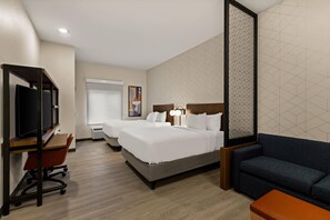 Een hotelkamer met twee bedden, een bureau met stoel, een bank en een televisie.