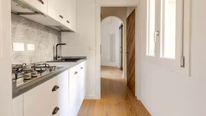 A narrow hallway with a kitchen area featuring a countertop, sink, and cabinets. - Apartment in Central Florence Near the Duomo (Florence)