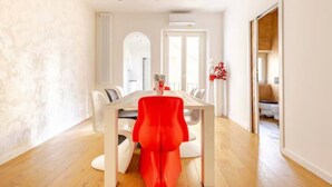 A dining area with a table and chairs, a radiator, and a door leading to another room. - Apartment in Central Florence Near the Duomo (Florence)