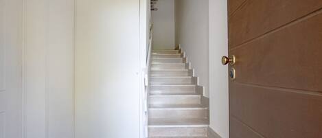 A staircase leading to a door with a brass handle.