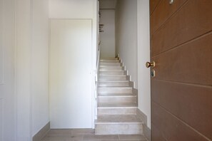 Eine Treppe führt zu einer Tür mit einer Messingklinke.