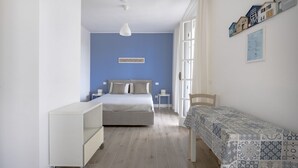 A bedroom with a bed, a bedside table, a chair, a small table, and a cabinet. - Large studio apartment perfect for two people, is located in a shared villa but has its own private access. It features a shared garden and a large furnished patio for exclusive use. The accommodation is located in Marina di Pulsano, a well-served seasid (Marina di Pulsano)