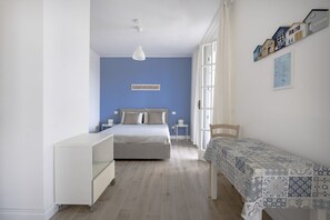 Ein Schlafzimmer mit einem Bett, einem Nachttisch, einem Stuhl, einem kleinen Tisch und einem Schrank.