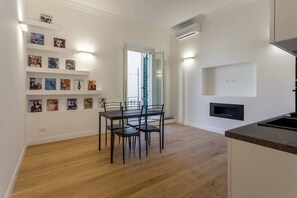 A modern kitchen with a built-in stove, a dining area with a table and chairs, and a wall-mounted TV.