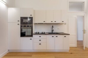 Cuina compacte amb forn integrat, fogó i rentatge.