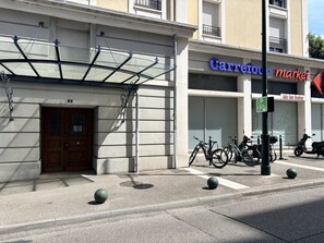 Ein Gebäude mit Glastür und einer Tür mit der Aufschrift 2, sowie ein Parkschild für Fahrradstellplätze.