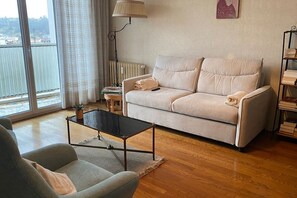 Ein Wohnzimmer mit einer Couch, einem Couchtisch und einem Bücherregal.