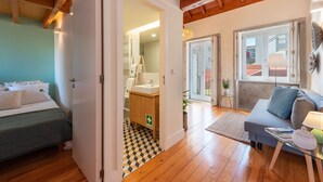 Una stanza con un letto, un bagno, un divano e una finestra.