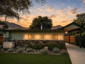 A house with a stone facade, a covered patio, and a view of mountains.