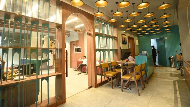 A hotel lobby with a reception desk, seating area, and a reception area with a sign. - Hotel Minaxi Palace (Bhinmal)