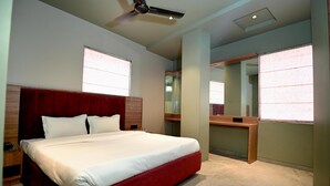 Una habitación de hotel moderna con una cama grande, un escritorio y un ventilador de techo.
