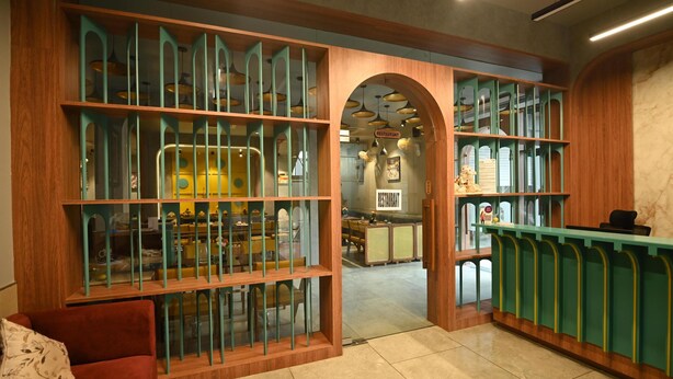 Un restaurante con interior de madera, separaciones de vidrio y una barra.