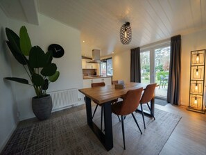 Eine moderne Küche mit weißen Schränken, einem Holztisch und einem Blumentopf.