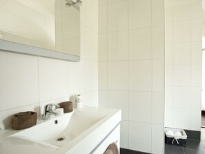 Ein Badezimmer mit Waschbecken, Spiegel und Handtuchhalter.