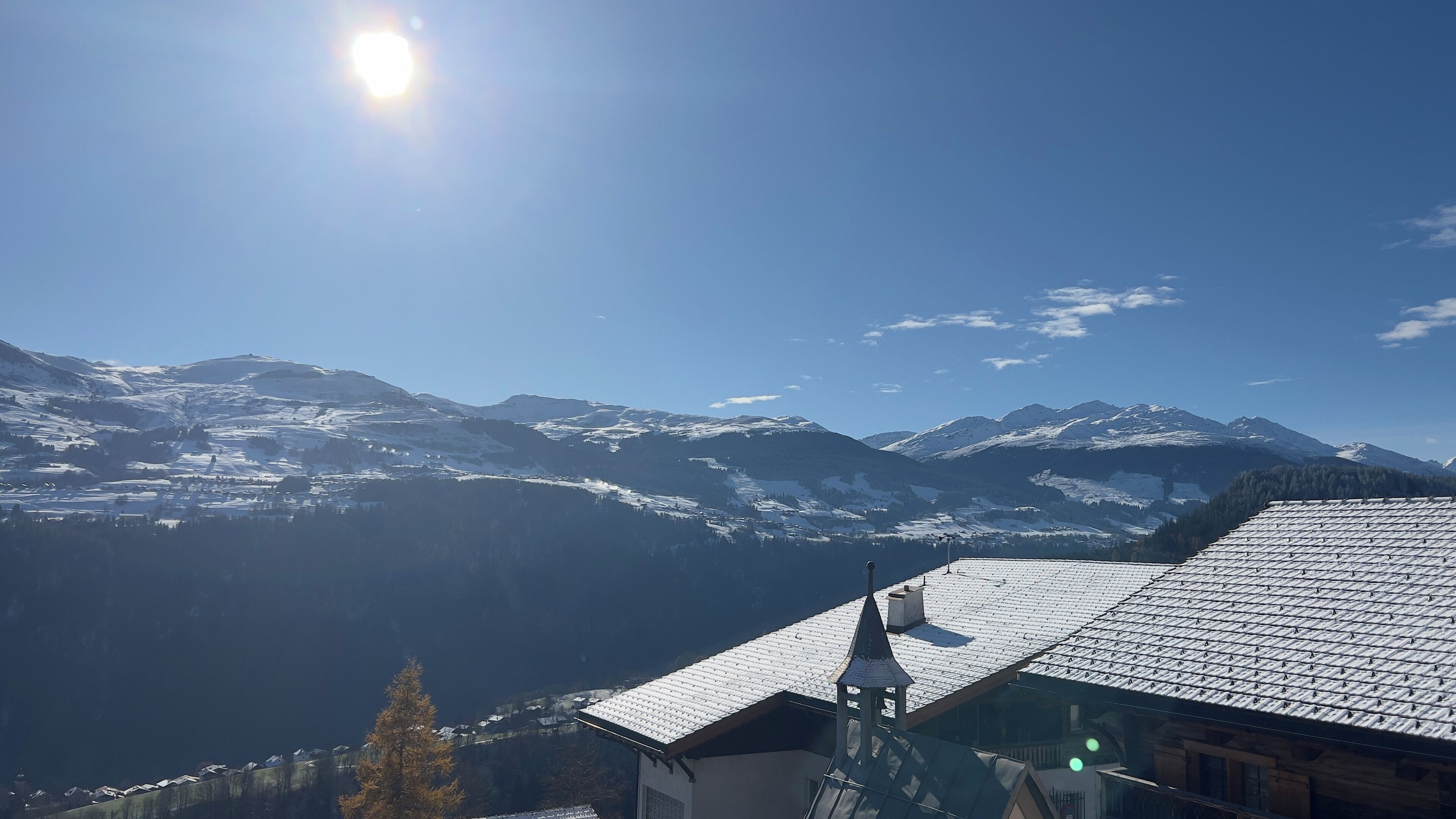 Un paysage de montagne avec des sommets enneigés et un ciel dégagé.