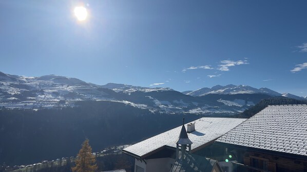 A mountain landscape with snow-covered peaks and a clear sky.