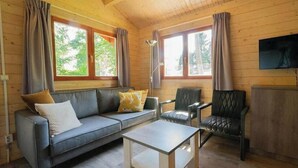 A cozy cabin interior with a sofa, armchair, and a small table. - Holiday Home in Maarn With Terrace (Maarn)