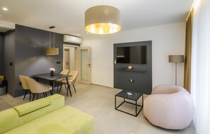 A modern living room with a sofa, a round chair, a coffee table, a TV, and a pendant light. - Awesome apartment in Metkovic with sauna (Metkovic)