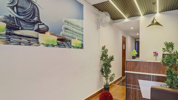 A reception area with a Buddha statue mural, a reception desk, and a fan on the ceiling. - RCC Hotels Park View Inn Miyapur (Hyderabad)