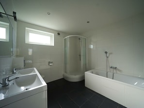 Ein modernes Badezimmer mit Dusche, Badewanne und Waschbecken.