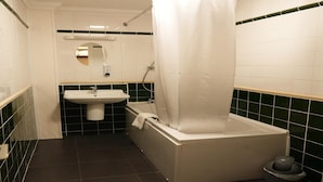 Ein Badezimmer mit Badewanne, Waschbecken, Spiegel und Toilette.