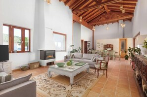 Amplia sala de estar con chimenea, comedor y cocina.