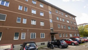 A multi-story building with a parking area in front. - VIA TAGIURA 25/27 - For Work and Leisure (Milan)
