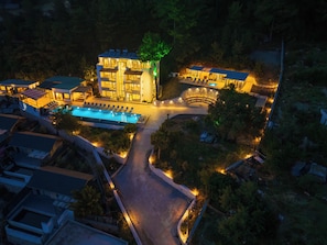 Un hôtel moderne doté d’une piscine, de nombreuses chambres et d’un espace paysager aménagé.