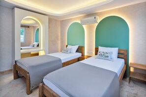 A hotel room with two beds, a large mirror, an air conditioning unit, and a view of the outdoors. - Turquoise Retreat Wellness & Spa (Kaş)