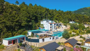 A modern resort with a pool, multiple buildings, and a forested hillside. - Turquoise Retreat Wellness & Spa (Kaş)