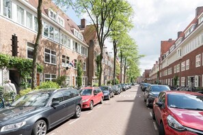 Een straat met geparkeerde auto's en klassieke bakstenen gebouwen.