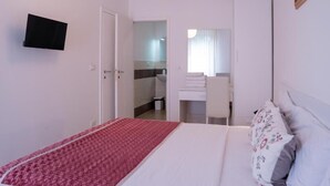 A bedroom with a bed, a television, a bathroom, and a mirror. - ca popolo venice (Mestre)