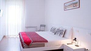 A bedroom with a bed, bedside table, lamp, and a framed picture on the wall. - ca popolo venice (Mestre)