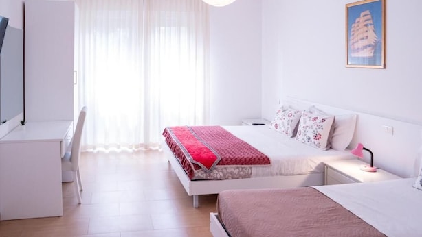 A bedroom with a bed, bedside tables, a desk, and a chair. - ca popolo venice (Mestre)