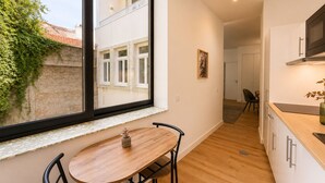 Una cocina moderna con un gran ventanal, suelo de madera y una zona de comedor con mesa y sillas.