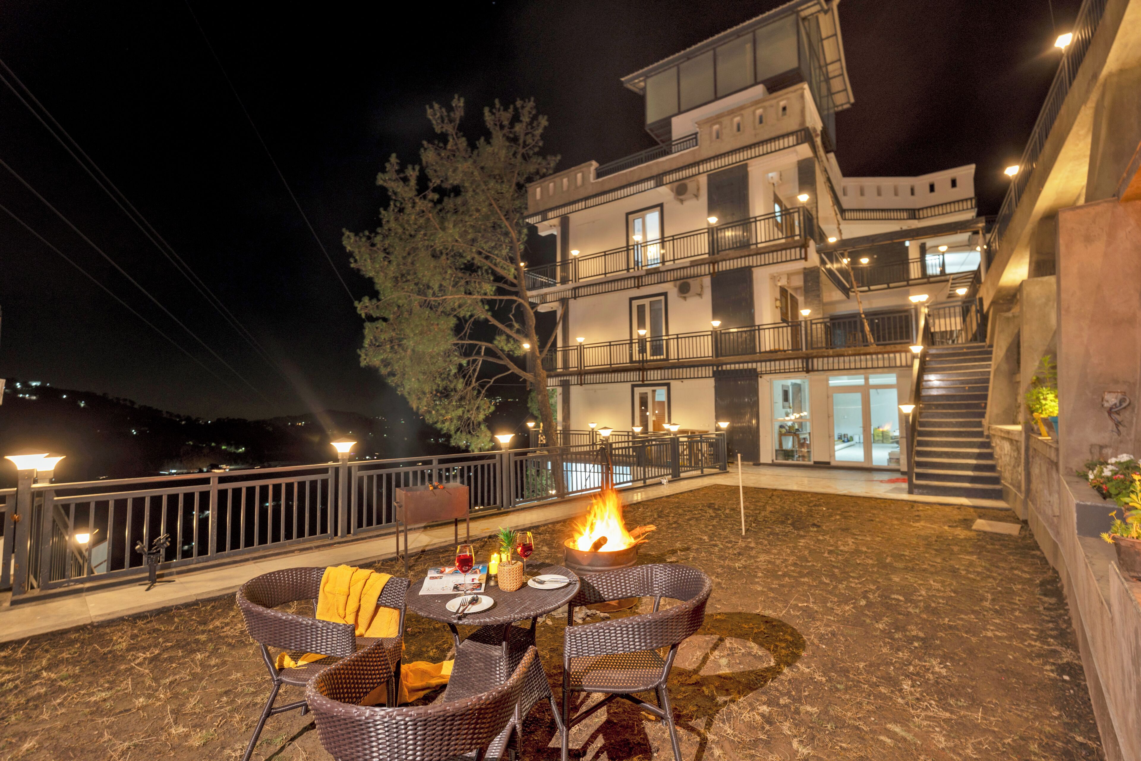 An outdoor patio with wicker chairs, a table, and a fire pit.