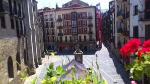 A street view with buildings, a central square, and a fountain. - Roquefer Bilbao by gaiarooms (Bilbao)