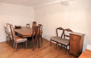 Ein Esszimmer mit Holztisch, sechs Stühlen, einer Bank und einem Schrank.