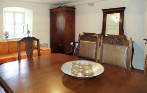 Ein Esszimmer mit Holztisch, Stühlen, einem Schrank und einem Spiegel.