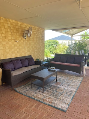 A covered outdoor seating area with two wicker sofas, a coffee table, and a patterned rug. - LAKELANDS LUXURY
Family and Pet Friendly
Opposite Park and  Near Village Centre (Lakelands)