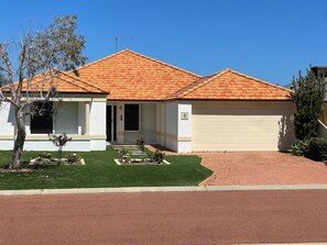 A two-story house with a red-tiled roof, a garage, and a well-maintained lawn. - LAKELANDS LUXURY
Family and Pet Friendly
Opposite Park and  Near Village Centre (Lakelands)
