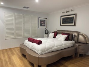 A bedroom with a bed, nightstands, a headboard, a window with blinds, and a framed picture on the wall. - LAKELANDS LUXURY
Family and Pet Friendly
Opposite Park and  Near Village Centre (Lakelands)
