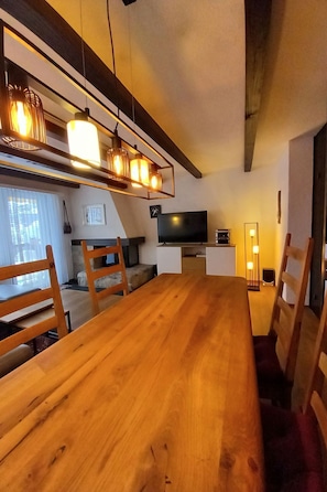 Ein modernes Wohnzimmer mit einem Holzesstisch, einem Fernseher und einem Kamin.