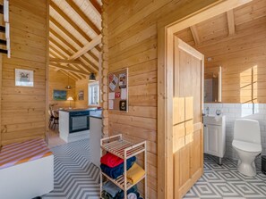 Ein Holzblockhaus-Interieur mit Küche, Essbereich und Bad.