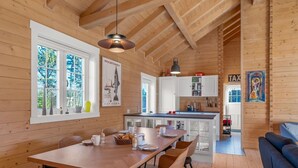 Een houten interieur met een eethoek, keuken en woongedeelte.