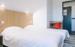 A hotel room with a bed, a desk, and a chair. - Welcomotel (Limoges)