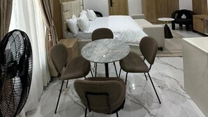 Une chambre d’hôtel moderne équipée d’un lit, d’un coin salon et d’une petite table.