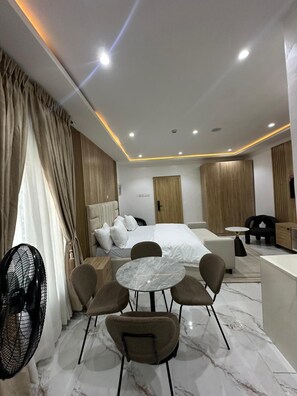 Ein modernes Hotelzimmer mit einem Bett, einer Sitzecke und einem kleinen Tisch.