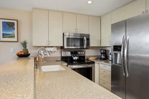 A modern kitchen with stainless steel appliances, a granite countertop, and light-colored cabinetry. - Napili Point 2 Oceanfront Villas, Sleeps 8 | Car Incl. w/ 6 nights | ML-4106 by KBM (Lahaina)