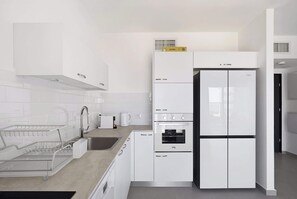 Eine moderne Küche mit weißen Schränken, einem eingebauten Backofen und einem Geschirrspüler.